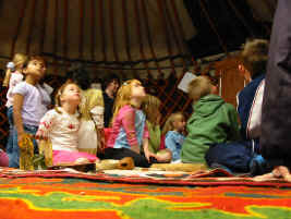 sitting on the felt rugs and looking up at the smoke hole in the yurt